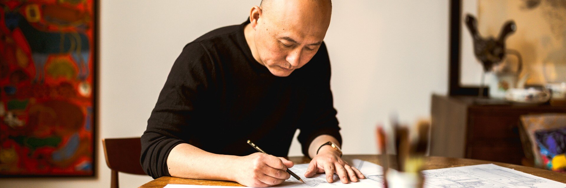  插画师江杉正在桌前绘制插图