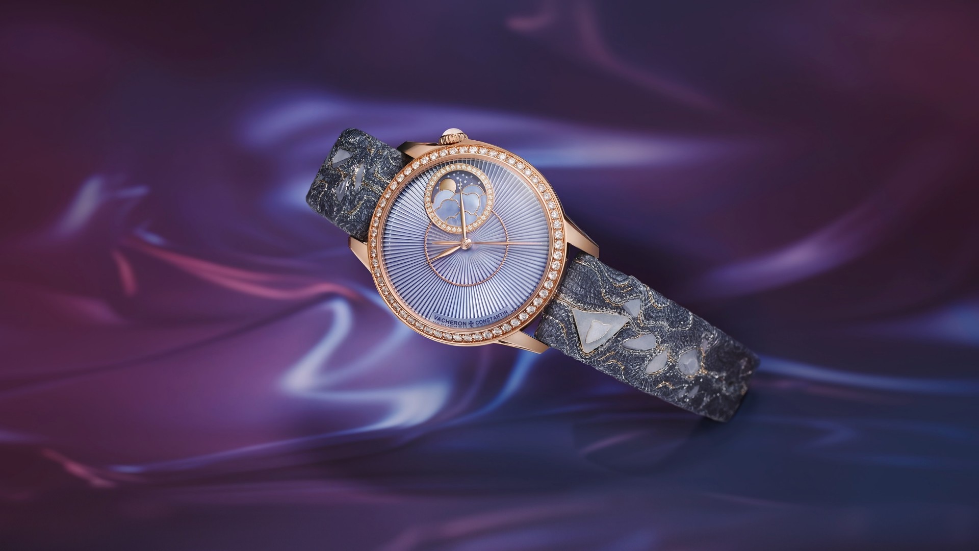Elegant women's watch with a round gold frame, purple case and interesting gray bracelet