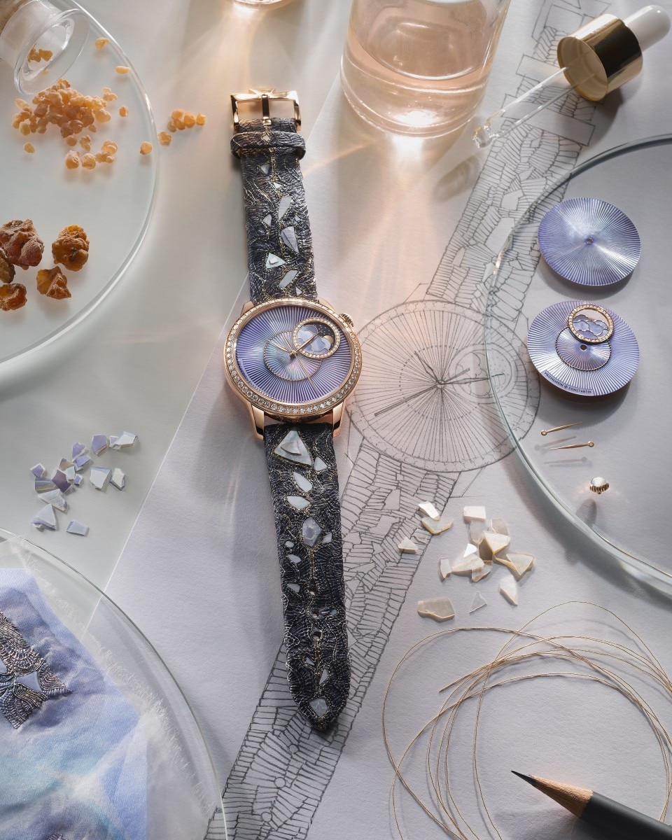 Flat lay os a single Egerie watch with a moon phase display, placed on a white textured surface.