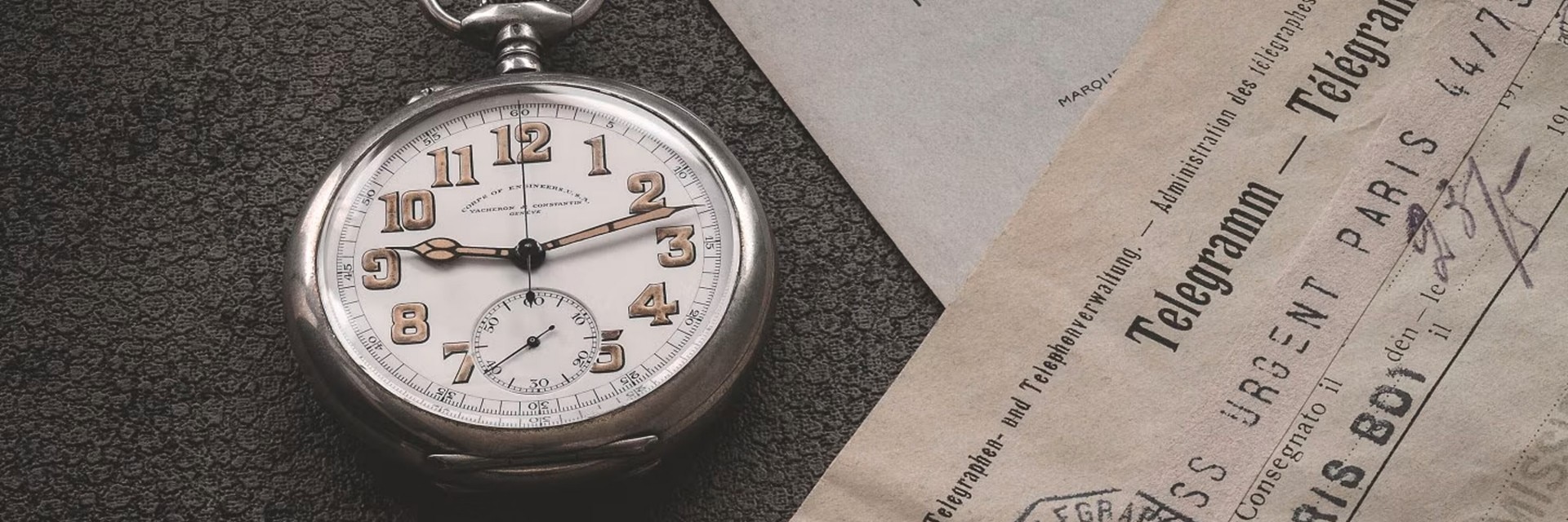 Close-up view of a round watch case with a silver frame and large gold numbers