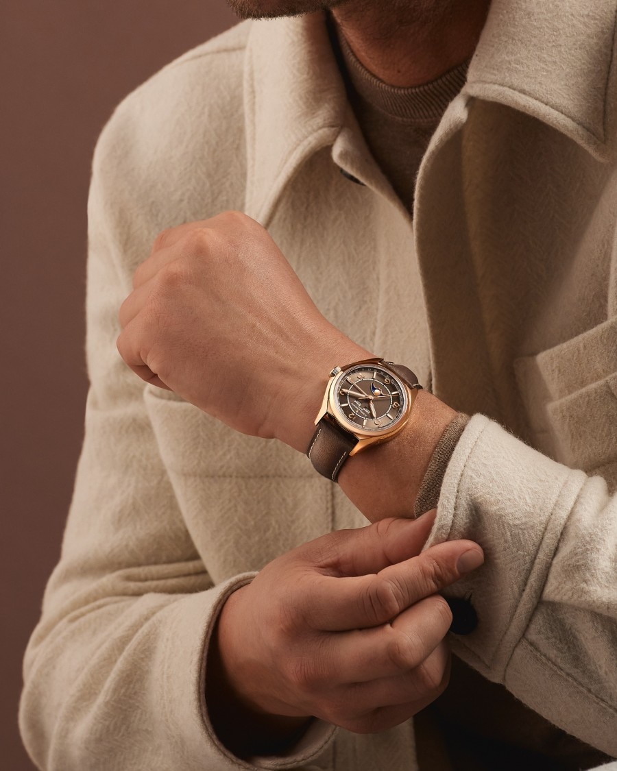  Fiftysix watch with gold case and brown leather strap.