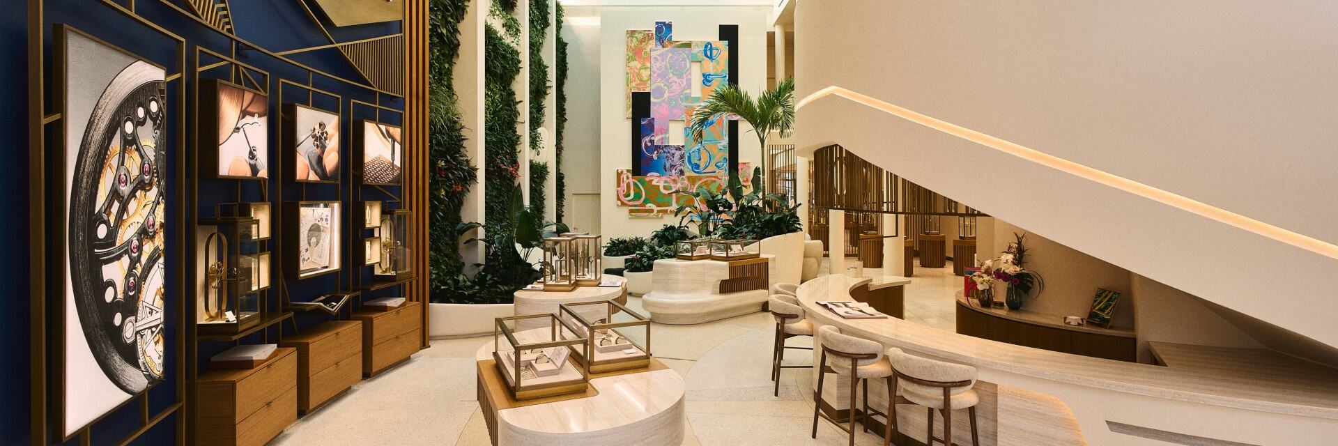 Interior view of a luxury boutique with display counters, modern geometric artwork, and a flower arrangement.
