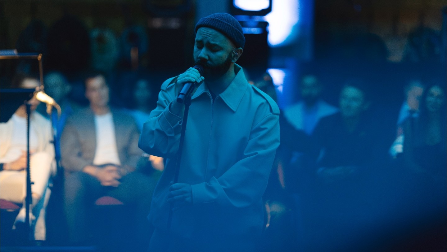 Woodkid singing on stage.