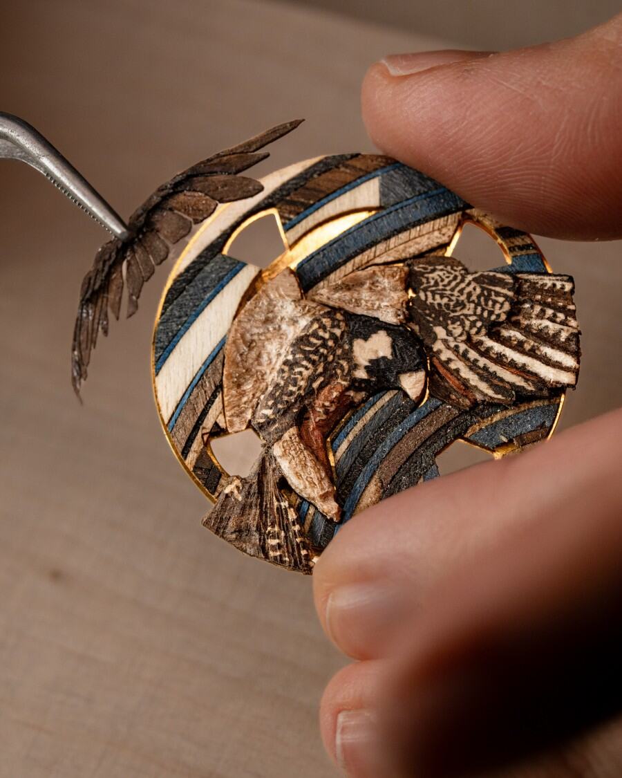 Close-up of a handmade bird wood inlay with fine natural wood details.