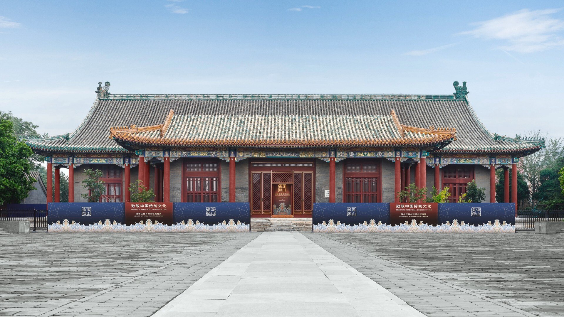 Front view of a traditional Chinese building with ornate roof details and red columns, captured under a clear blue sky.