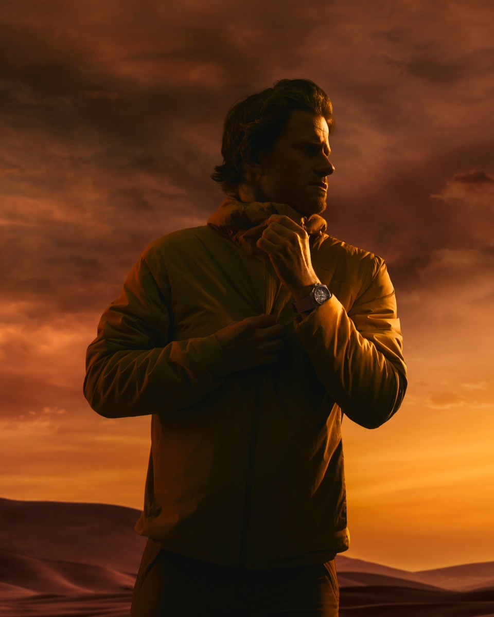 Cory Richards looking at the horizon with an orange desert background