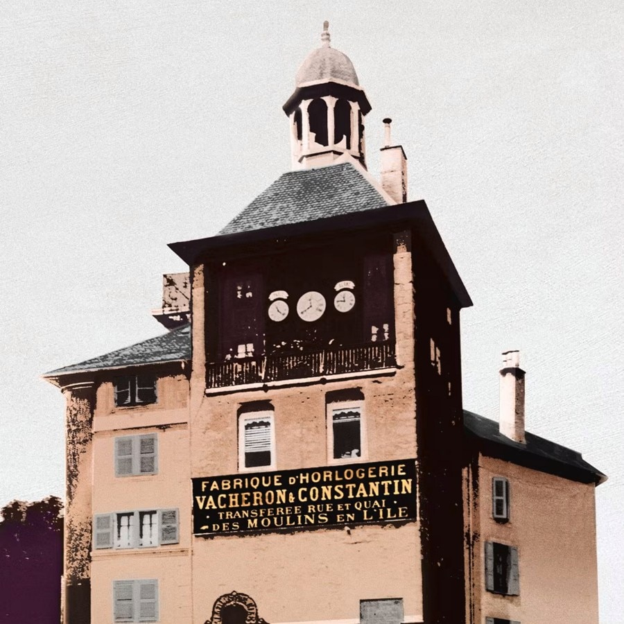 Historic Vacheron Constantin watchmaking building with a clock tower and signage.