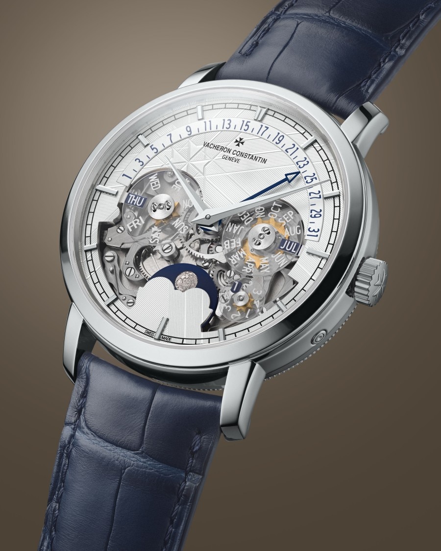 Traditionnelle - Openface A stylish watch with a blue leather strap, silver case, transparent dial showcasing the mechanical movement, and additional sub-dials.
