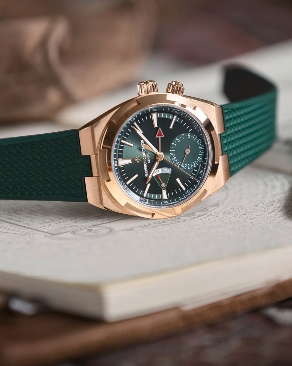 Vacheron Constantin chronograph with a green strap and dial, resting on a closed white book.