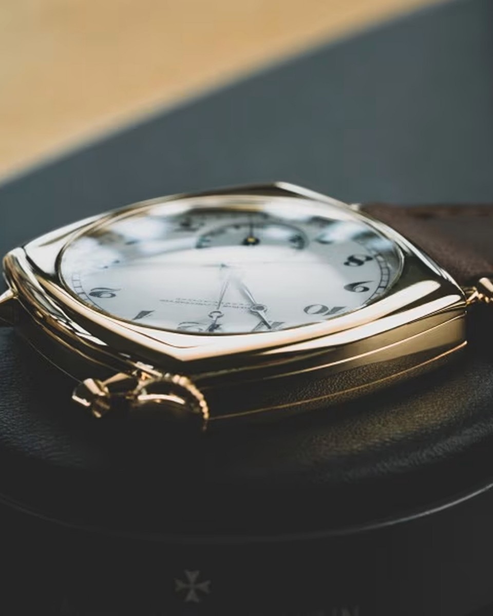 Side view of a vintage Vacheron Constantin watch showing the curved glass and gold case.
