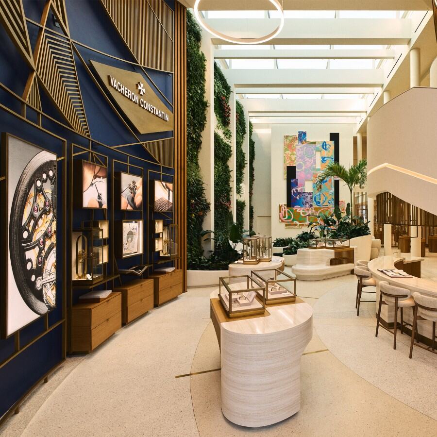 Interior view of a luxury boutique with display counters, modern geometric artwork, and a flower arrangement.