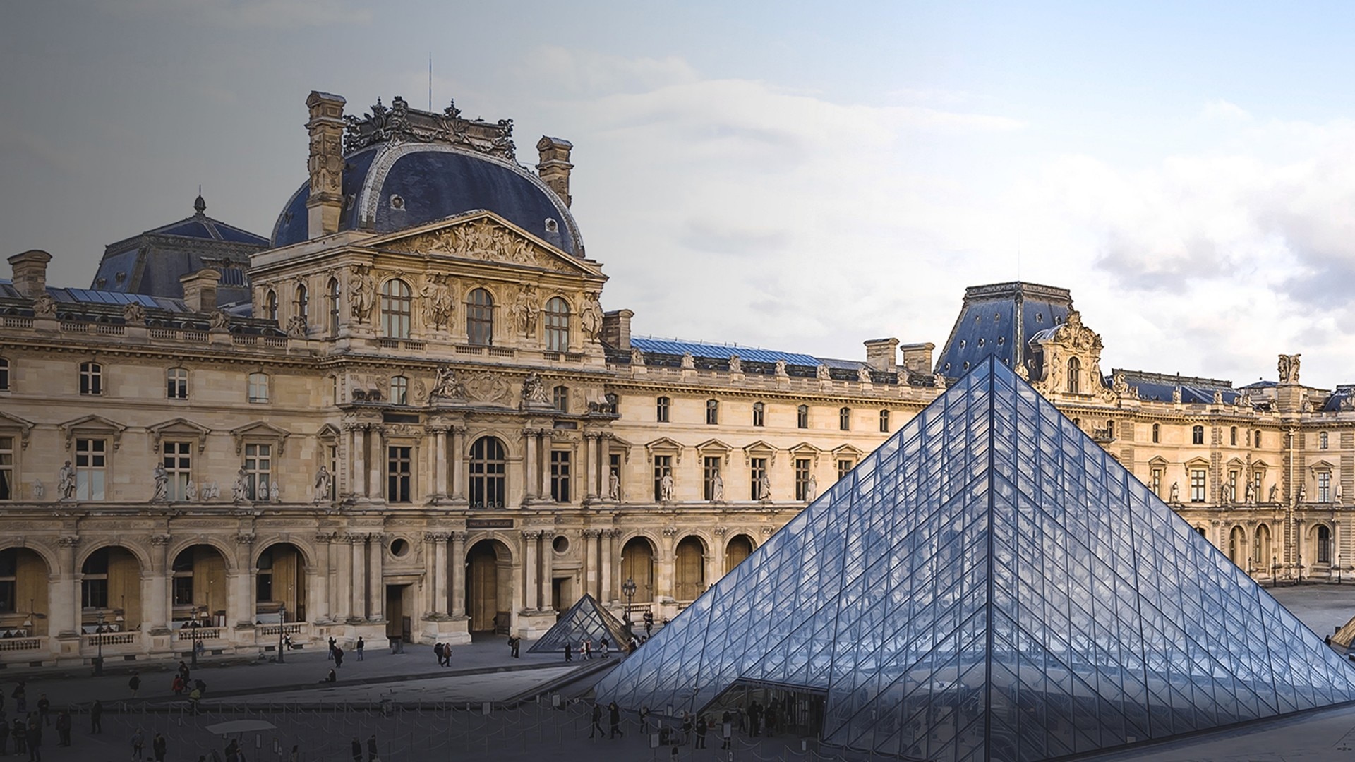 艺术博物馆展厅陈列古典雕塑，游客驻足欣赏。