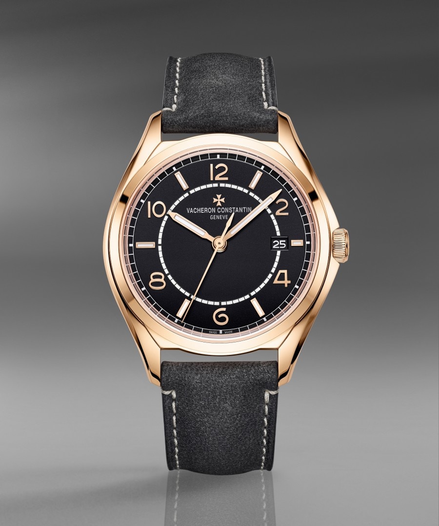 Fiftysix self-winding A luxury wristwatch with a black dial, gold case, and a leather strap.