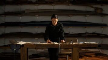 Artist crafting a handmade bird wood inlay piece.