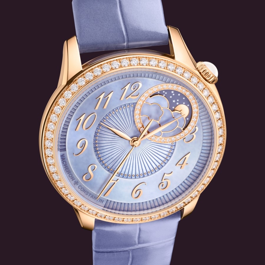 Gold Vacheron Constantin Egerie watch with a lavander strap and diamond-set bezel, displayed against a black background.