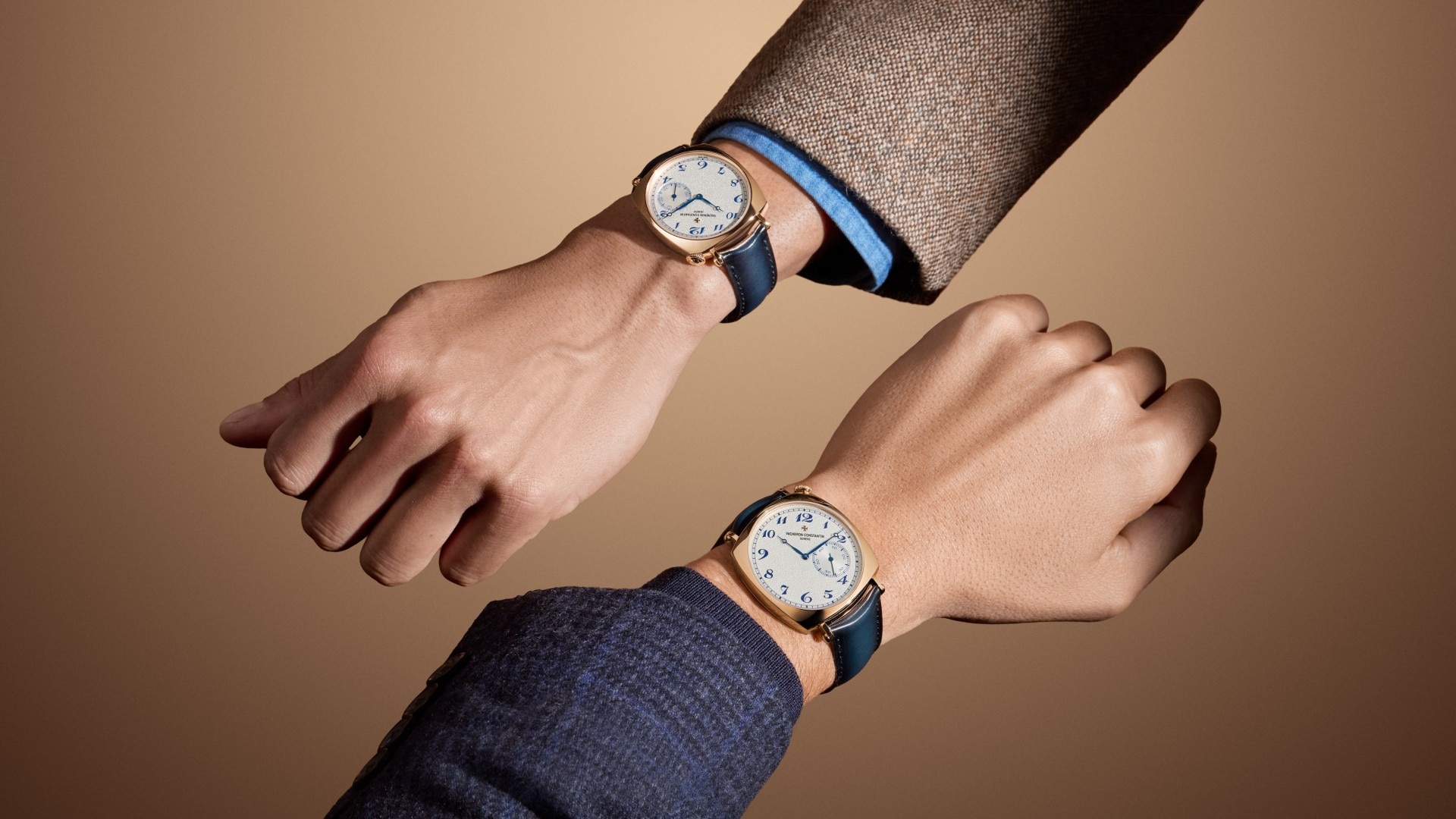American 21 watch worn on the wrist with a blue leather strap, a gold bezel, and a light-colored case.