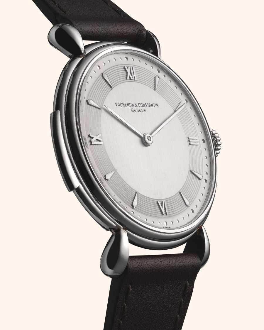 A classic round silver watch with a dark leather strap.