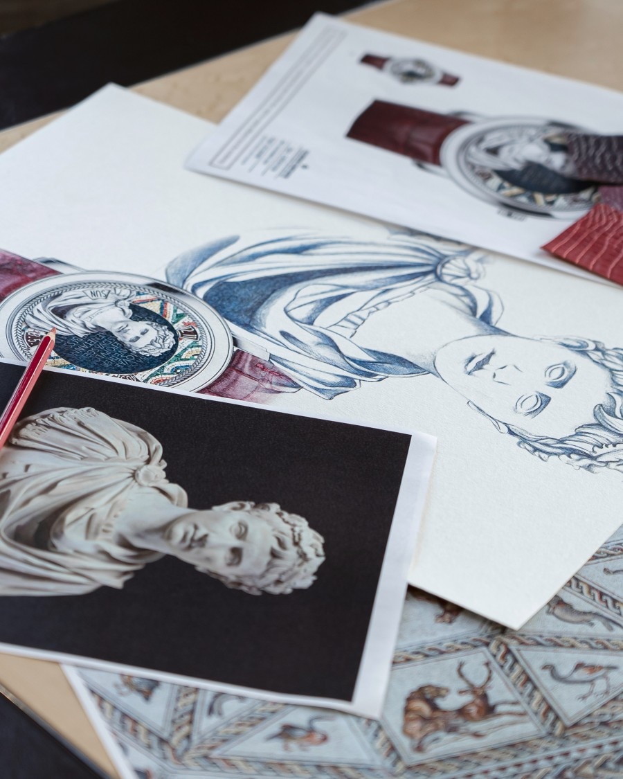 Art sketches and printed visuals laid out on a desk.