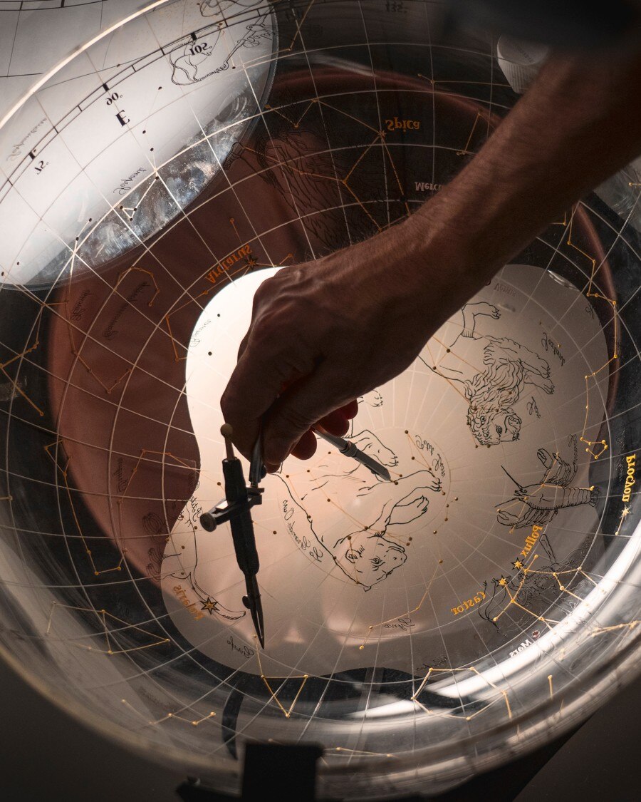 Miniature painting on curved glass Image illustarting a compass on a transparent world map