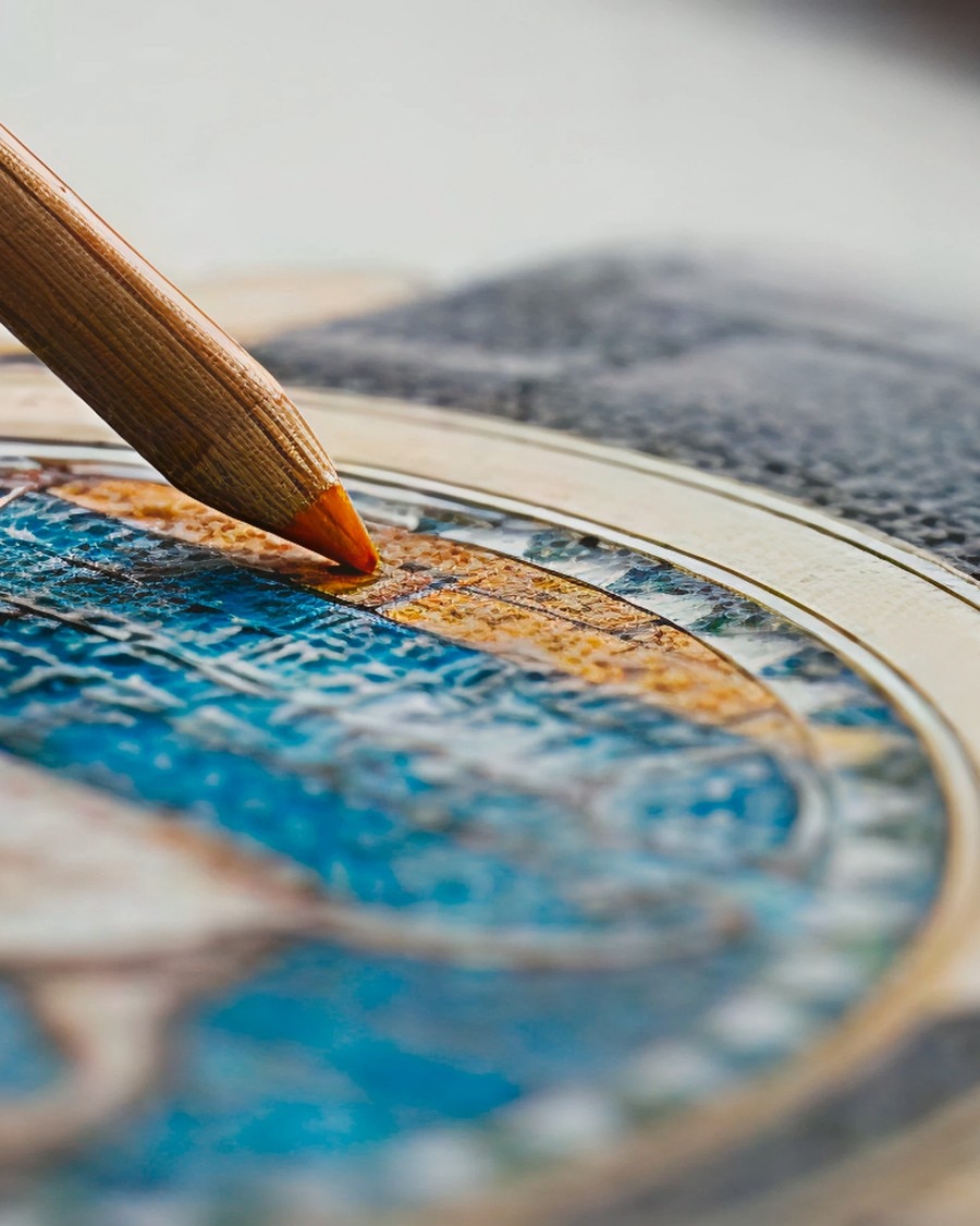 工艺、艺术与文化 Detailed view of a hand painting blue and gold details on a watch dial using a fine brush.