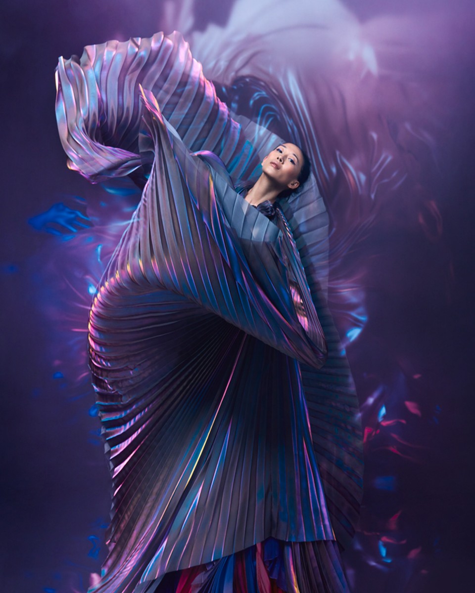 Dramatic image of a woman dancing in a voluminous, flowing purple gown, mid-motion.