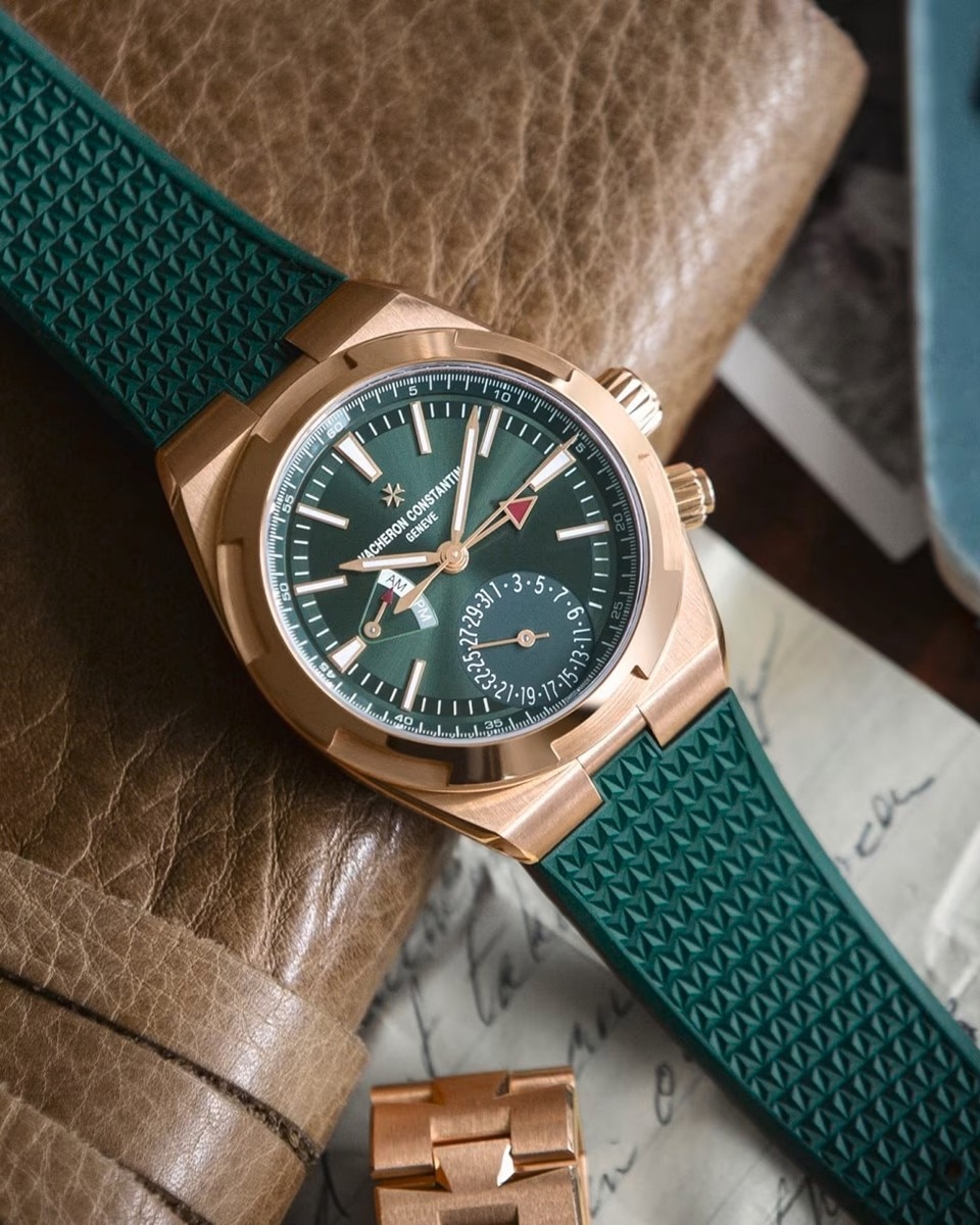 Vacheron Constantin chronograph with a green dial and green strap, placed on a leather surface.