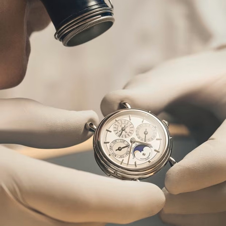 Craftsman inspecting a mechanical part through a loupe