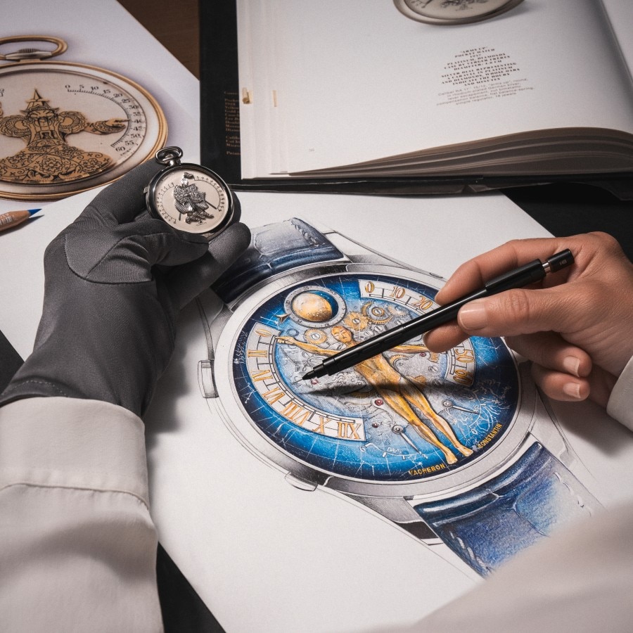 Designer drawing a watch with a pencil in one hand on a sheet of paper, holding a pocket watch in the other hand with a black glove.
